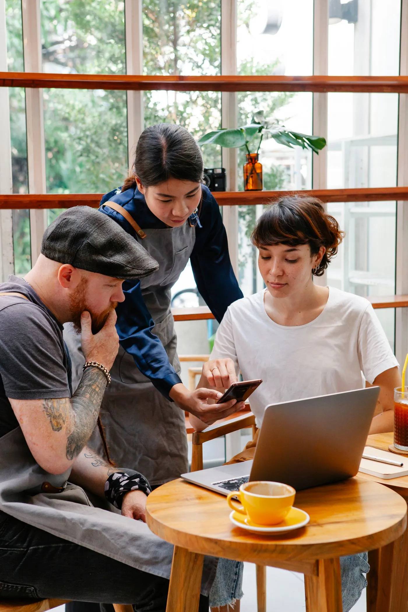 A café team checking a laptop together at a table
