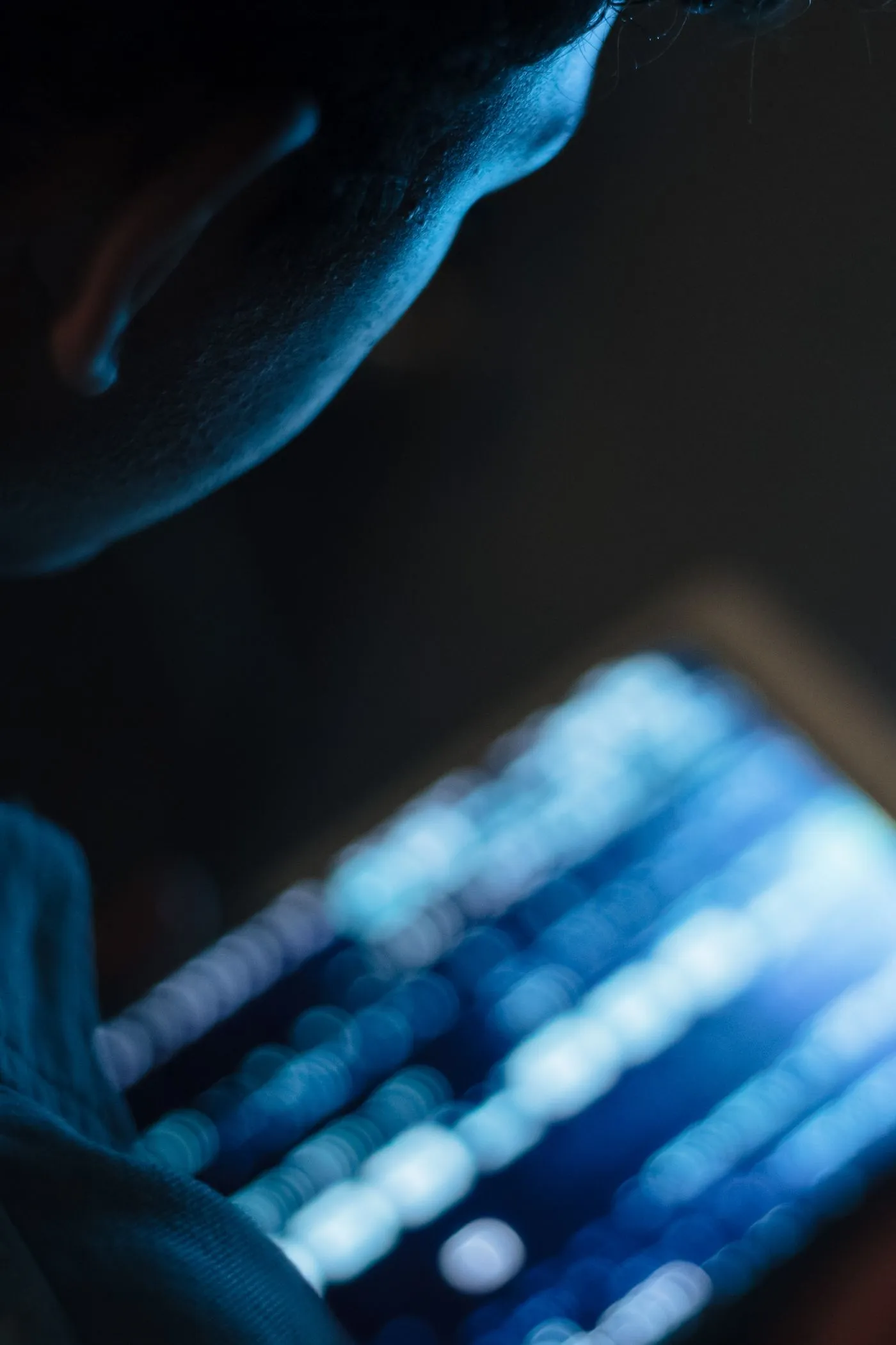 A developer lit by the glow of code on a screen