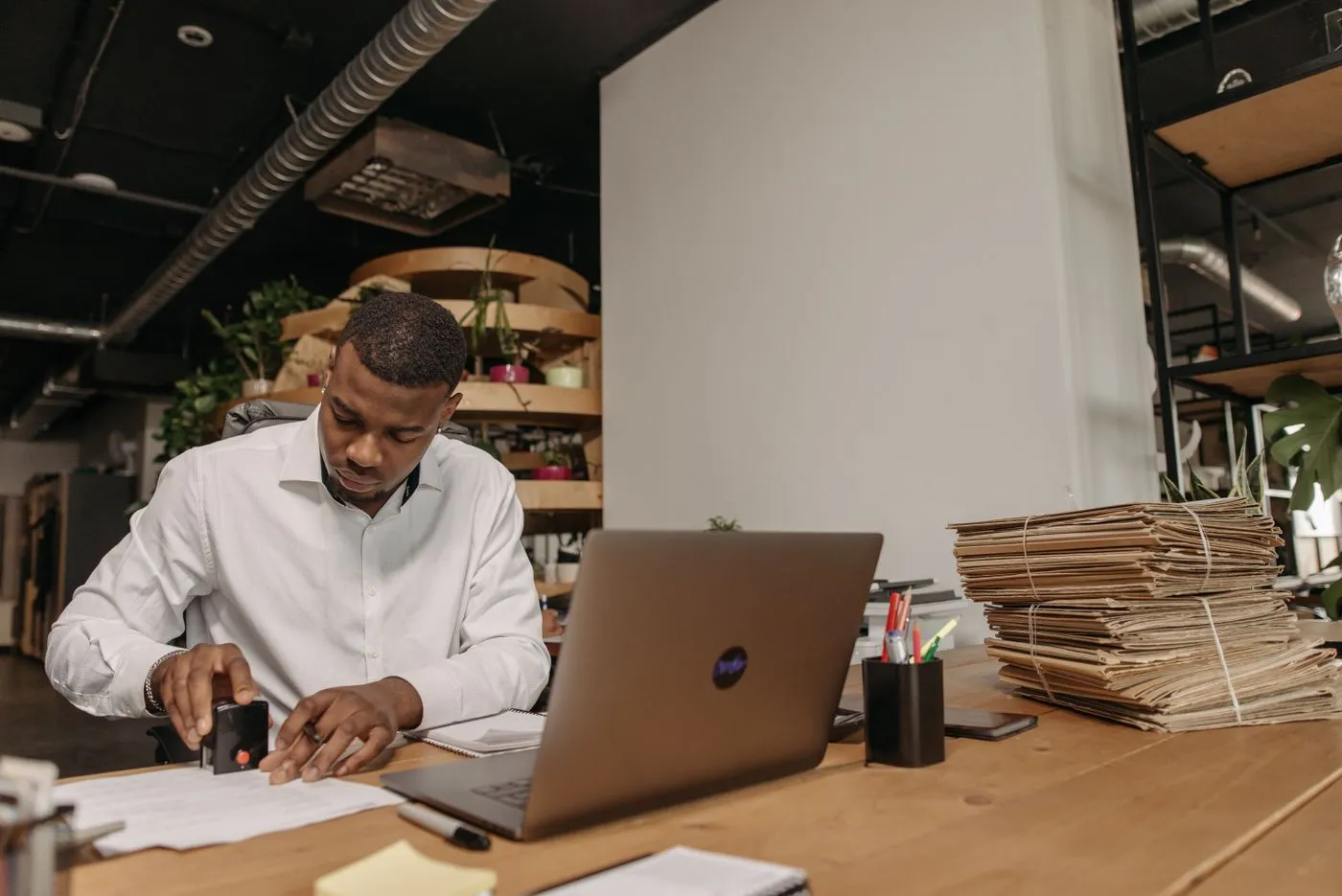 A man reviewing paperwork beside his laptop in an office